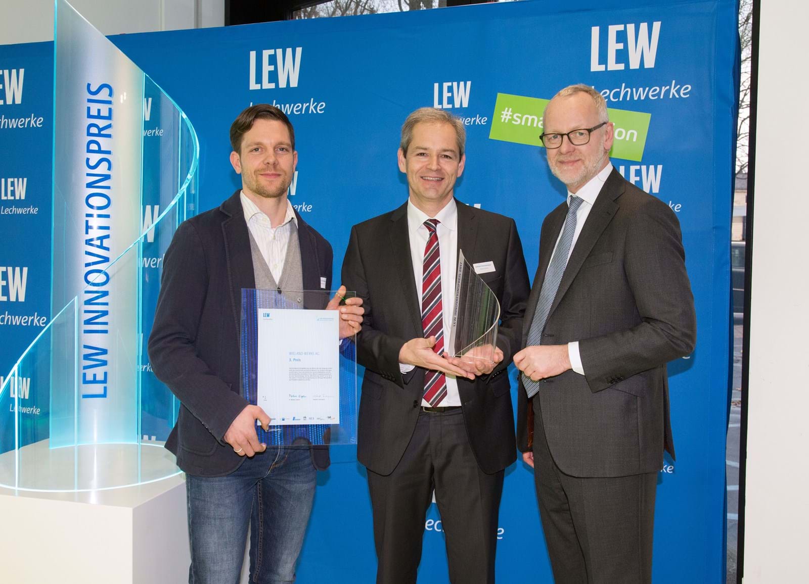 LEW-Vorstandsmitglied Dr. Markus Litpher (r.) überreicht Pokal und Urkunde für den 3. Platz beim LEW Innovationspreis an Benjamin Schwarz (l.) und Eckhart Zimmermann von der Wieland Werke AG.