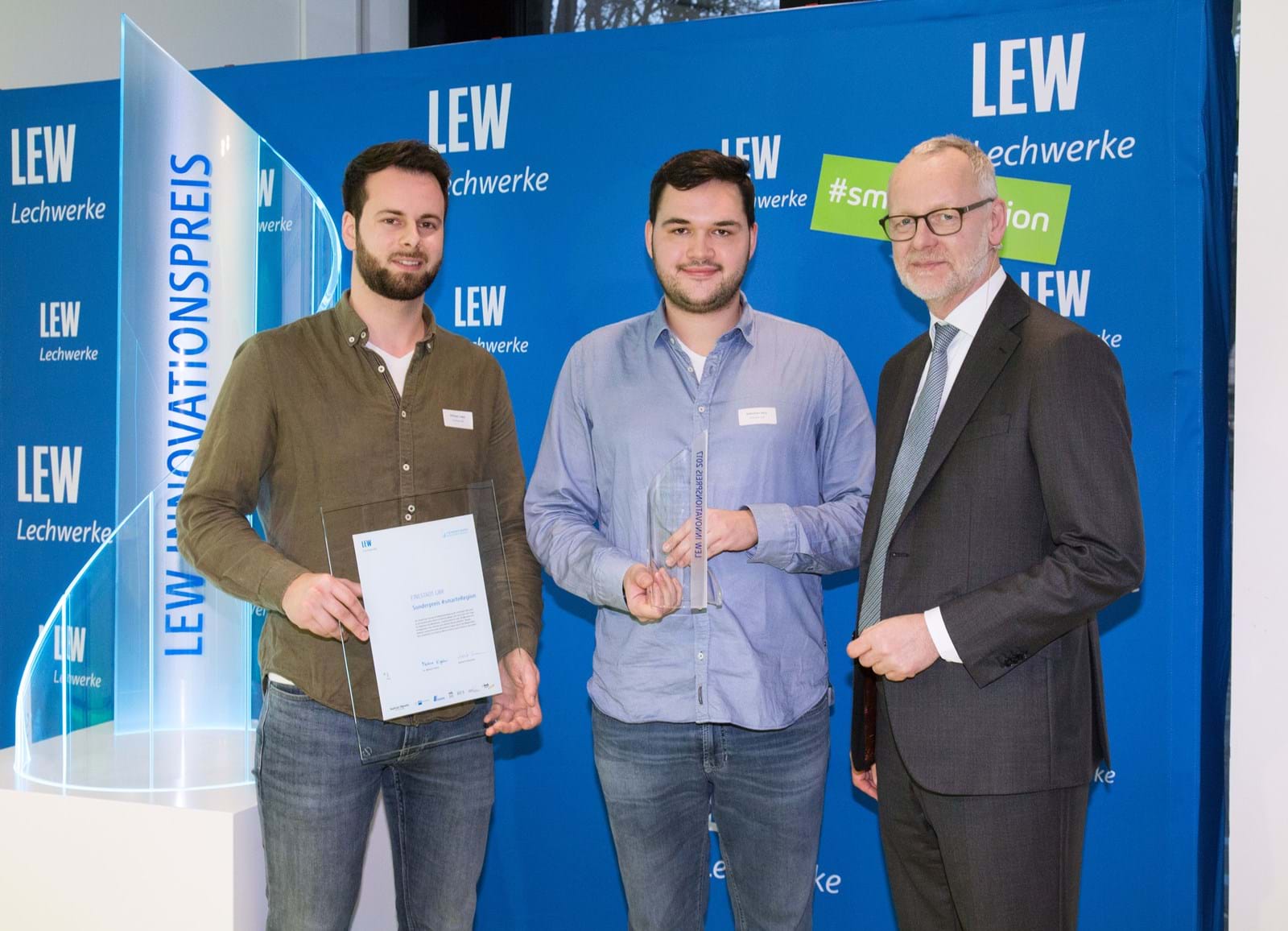 LEW-Vorstandsmitglied Dr. Markus Litpher (r.) überreicht Pokal und Urkunde für den Sonderpreis #smarteRegion an Michael Lodes (l.) und Sebastian Seitz von der EineStadt GmbH.